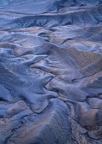 Serpentine Erosion and Color Layers Serpentine erosion patterns with dendritic flow and visible blue and gold soil layers, photographed by Cindy Beckett in Hanksville, Utah after sunrise.