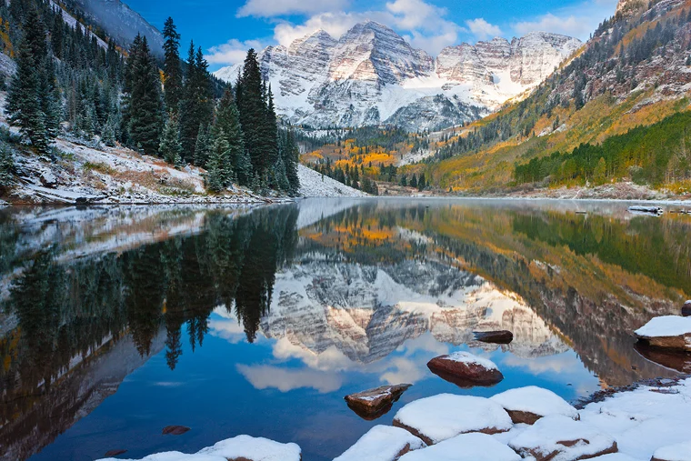 Autumn, morning image of Maroon Bells reflecting in Maroon Lake after a light snow.