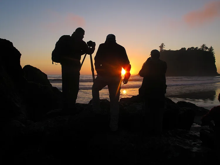 Group of photographers photographing sunset at a beach.