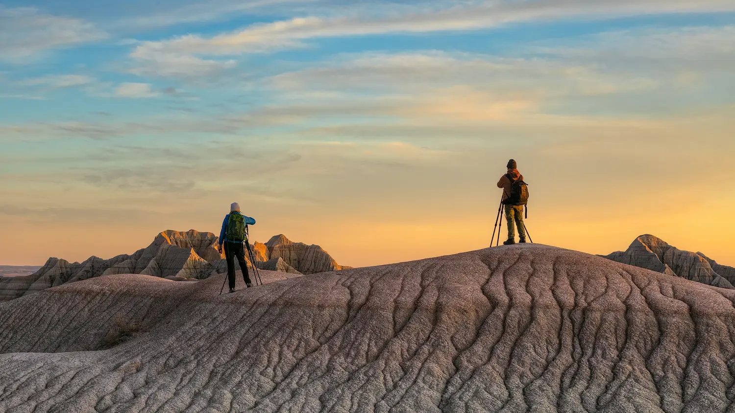 Workshop participants photographing a scenic badlands landscape at sunset.