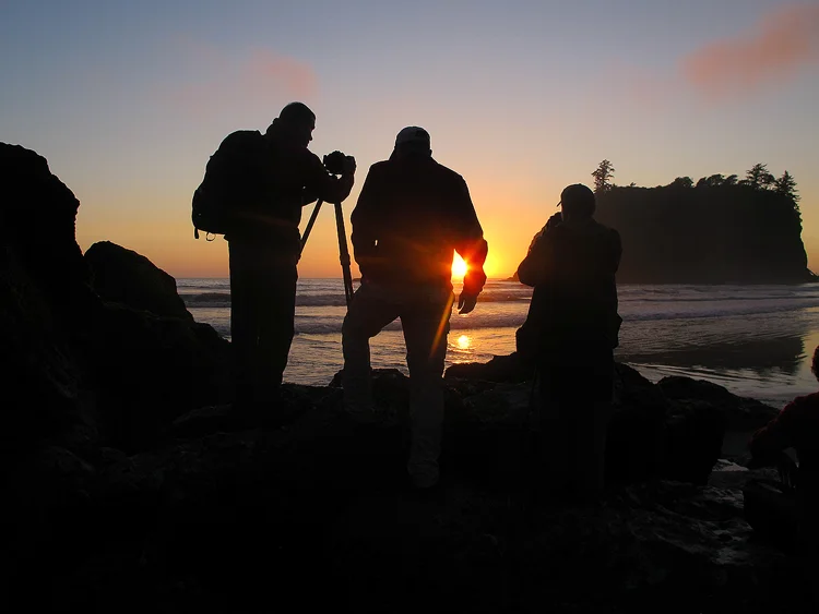Real Stories, Real Locations, Discover Our Workshops A photography workshop group enjoying a sunset at the beach.