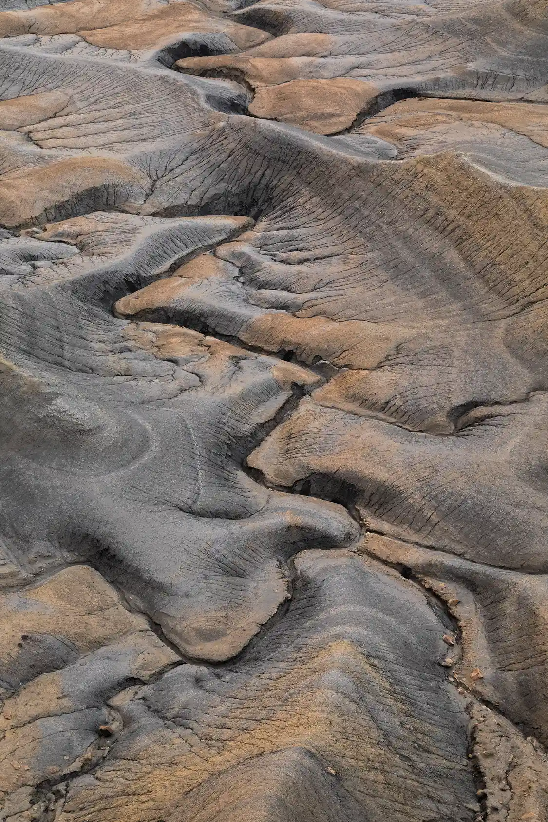Curving drainage lines etched into colorful desert soil at Moonscape Overlook, Utah.