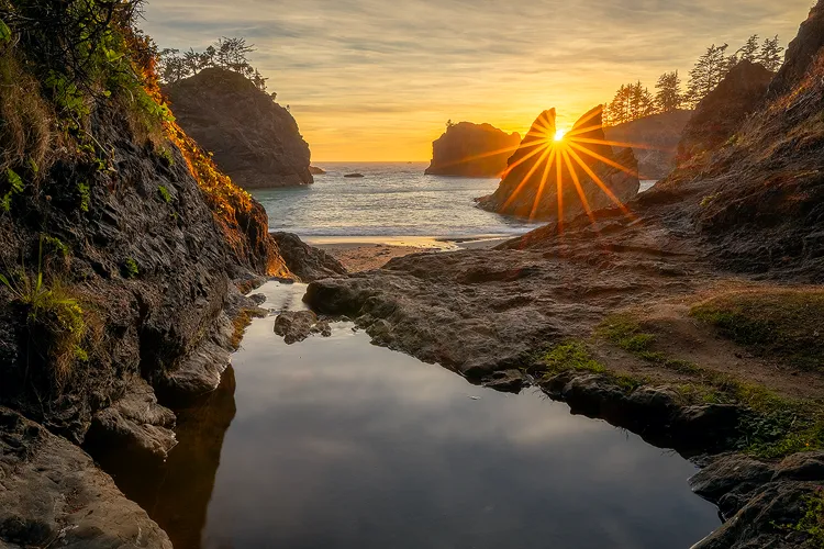 Sunset with a sun star through sea stacks at Secret Beach, Samuel H. Boardman State Scenic Corridor.