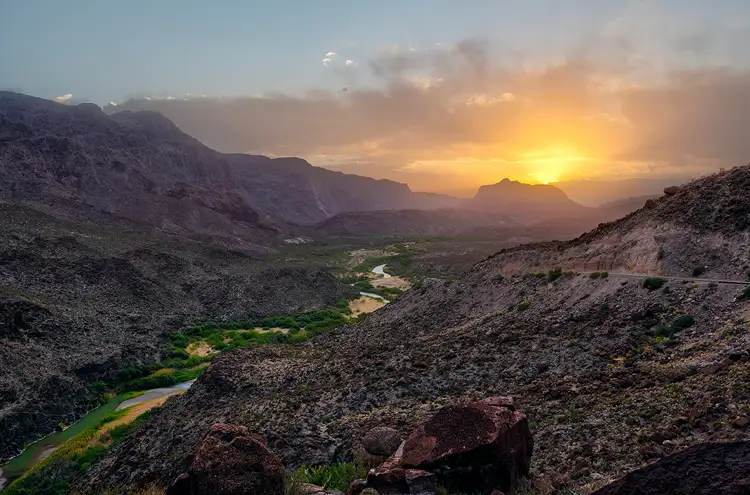 Sunset above the Rio Grande winding through a canyon in Big Bend Ranch State Park.