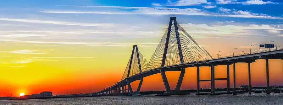 Arthur Ravenel Jr. Bridge sweeping across Charleston Harbor at sunset.