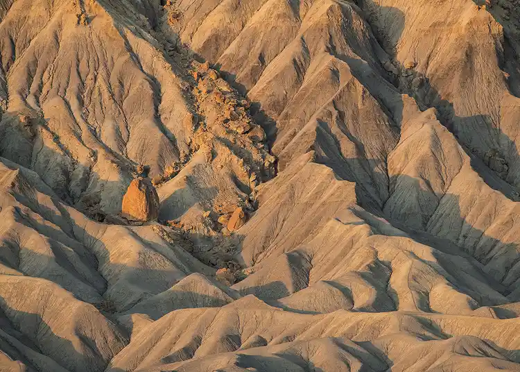 Morning light revealing sculpted gullies and ridges below Factory Butte near Hanksville, Utah.