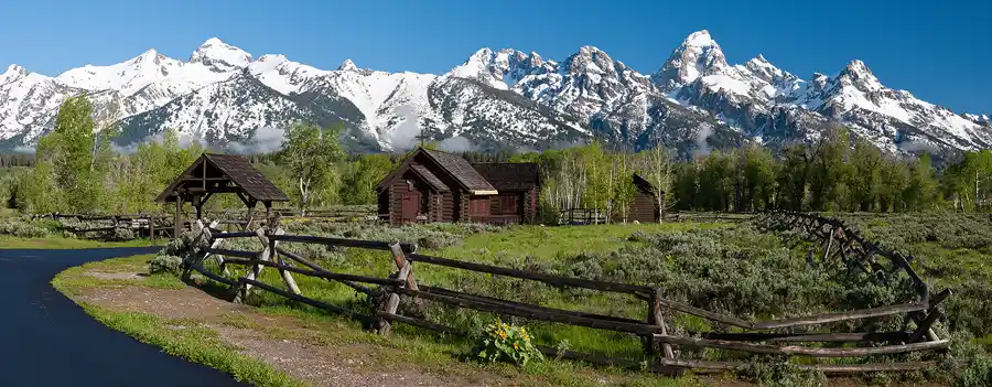 The Chapel of the Transfiguration surrounded by spring meadows beneath the Teton Range in Grand Teton National Park.
