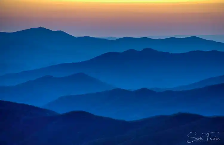Layered mountain ridges fading into the distance beneath a colorful sunset in Great Smoky Mountains National Park.