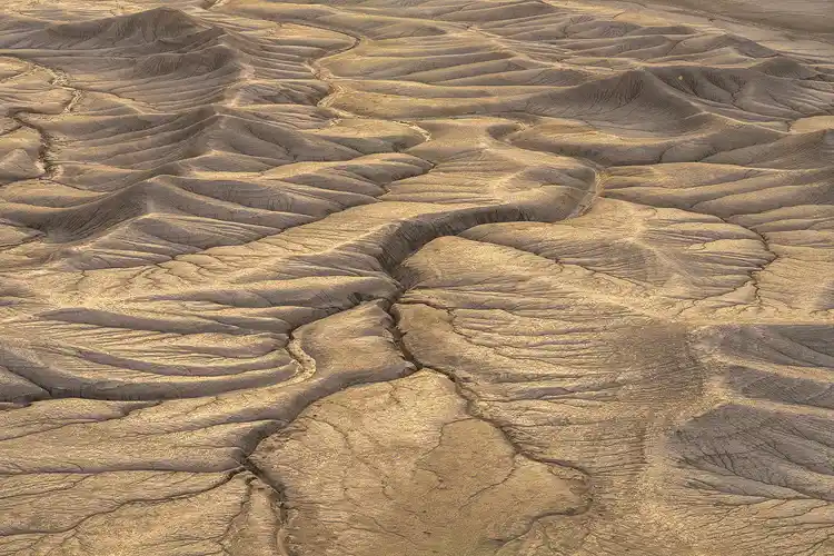 Morning light revealing winding drainage channels through the rolling badlands at Moonscape Overlook near Hanksville, Utah.