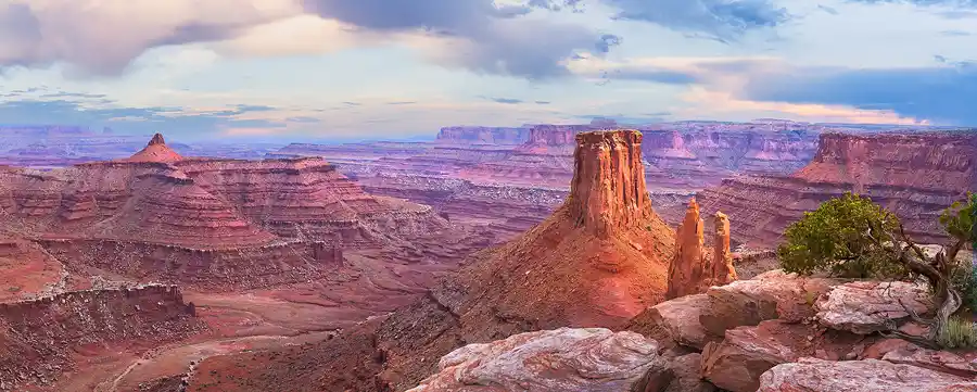 Evening light illuminating a sandstone monolith above the vast canyons of Marlboro Point near Canyonlands National Park.