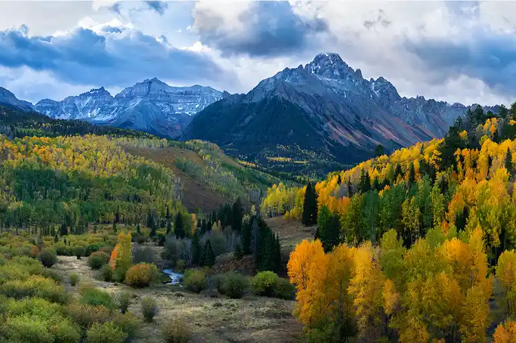 Golden aspens leading through the Dallas Creek valley toward Mount Sneffels in the San Juan Mountains of Colorado.