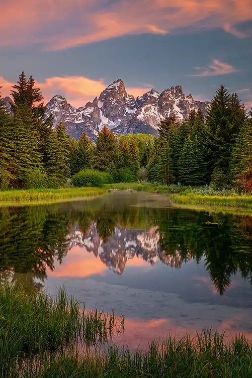 Colorful sunrise reflected in the beaver ponds at Schwabacher Landing beneath the Teton Range, Grand Teton National Park.