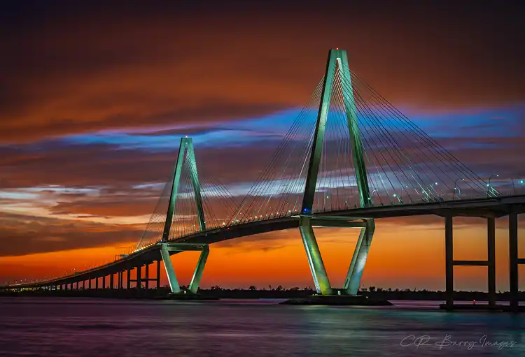 Arthur Ravenel Jr. Bridge silhouetted against a fiery sunset in Charleston.